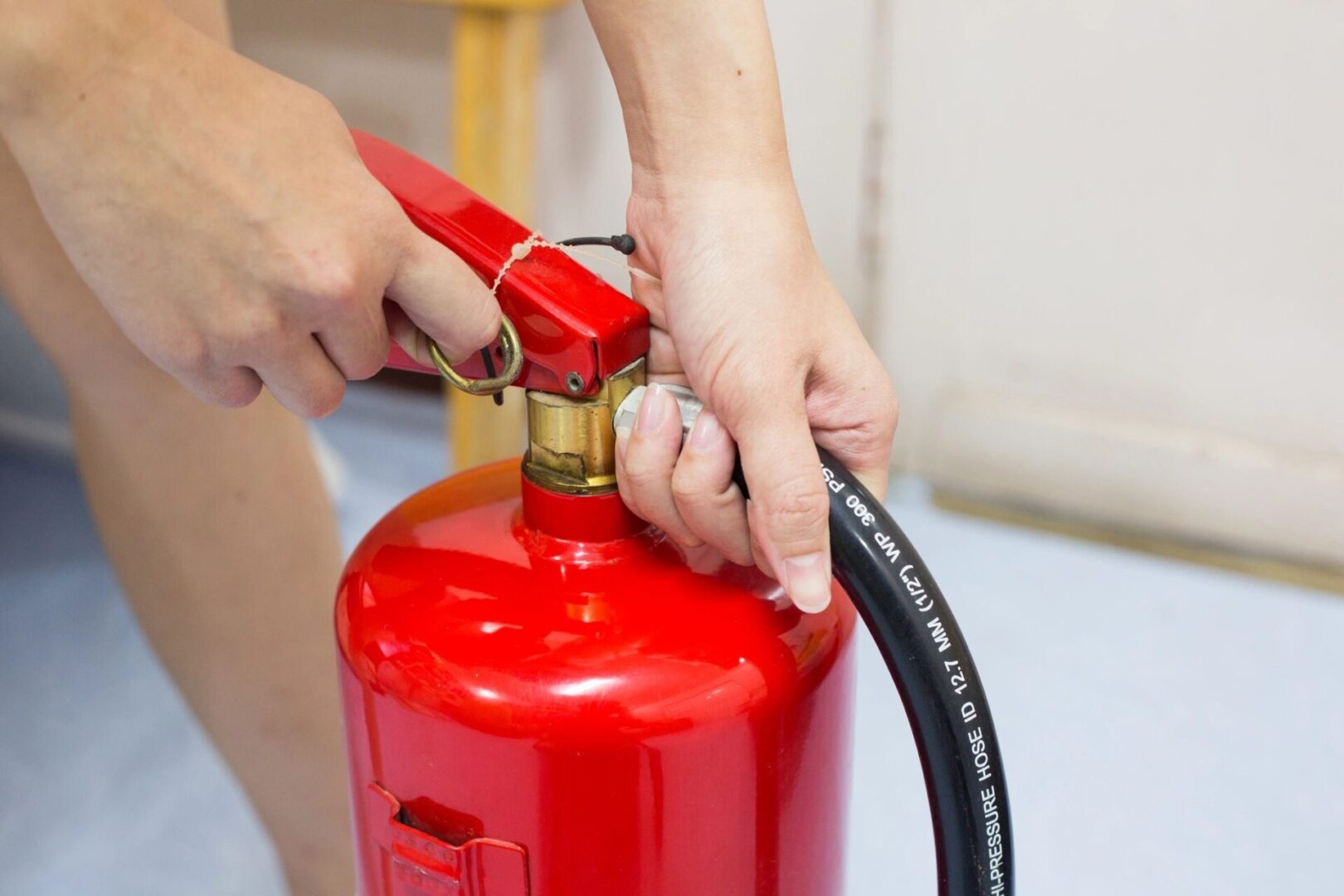 A woman is holding a red fire extinguisher.
